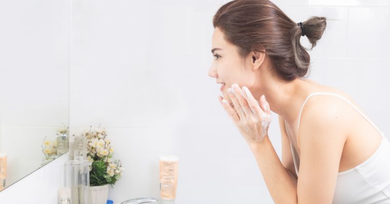 鏡を見ながら洗顔する女性の横顔