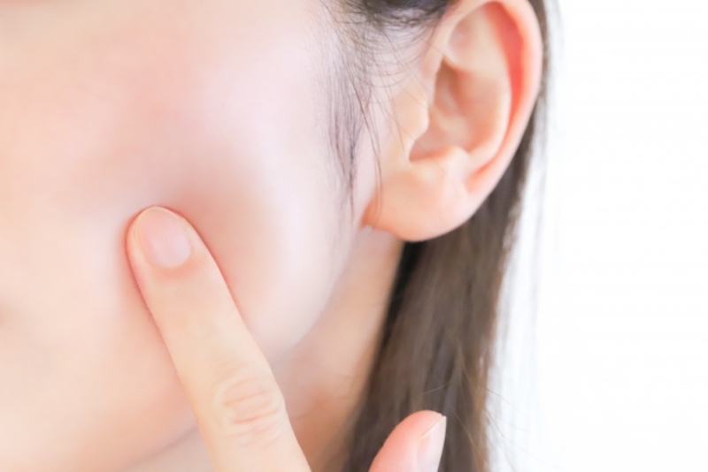 頬に指をあてている